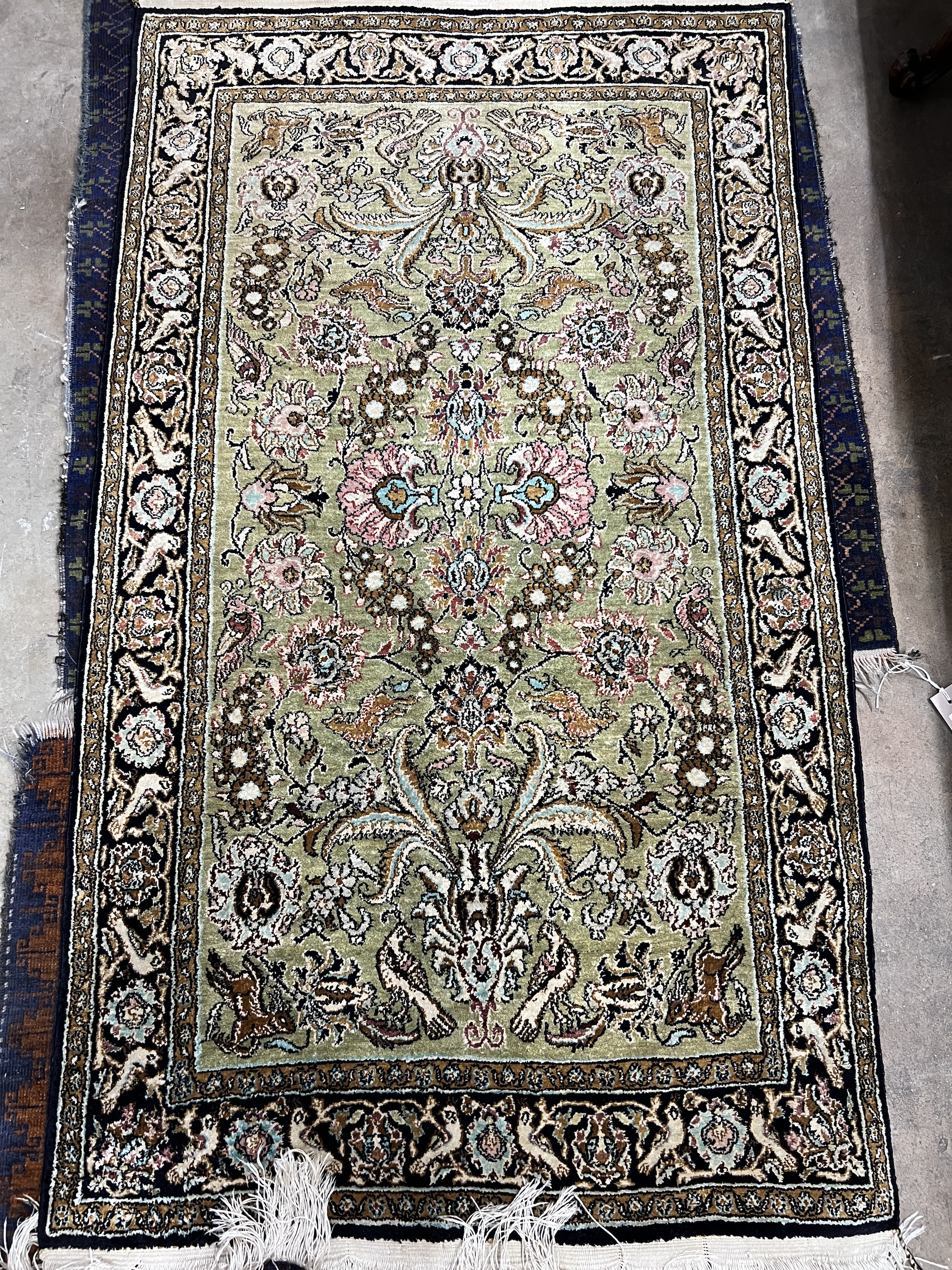 A Kashan part silk rug, woven with animals among flower heads, 130 x 77cm